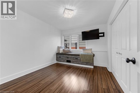 A bedroom with a bed and a wooden floor.
