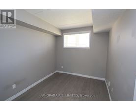 A room with a window and wooden flooring is for sale.