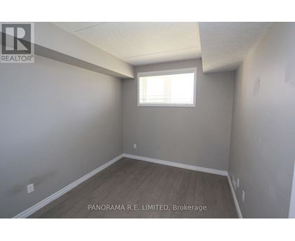 A room with a window and wooden flooring is for sale.