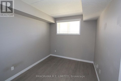 A room with a window and wooden flooring is for sale.