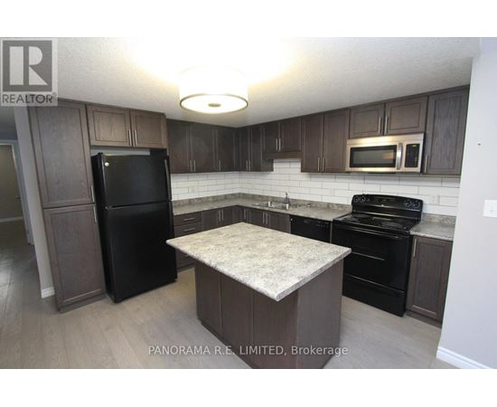 A kitchen with a black fridge, black oven, and black microwave.