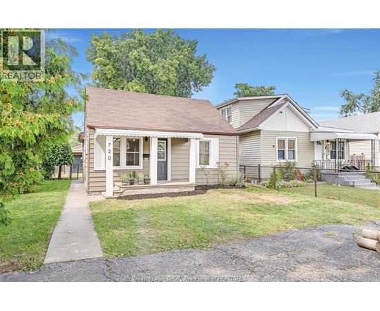 A house with a brown roof and a porch with a white railing.
