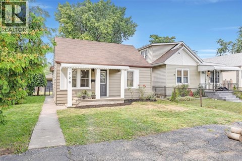 A house with a brown roof and a porch with a white railing.