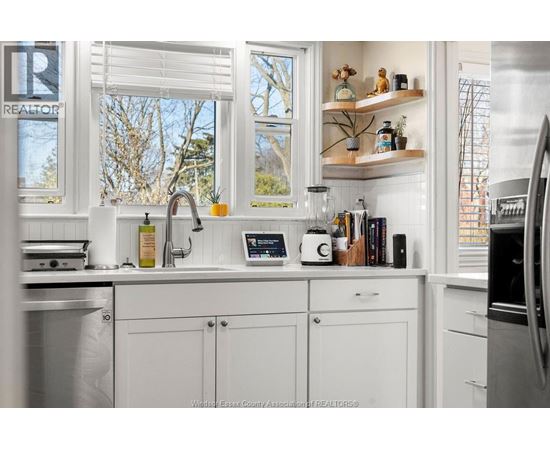 A kitchen with white cabinets and a window above the sink.