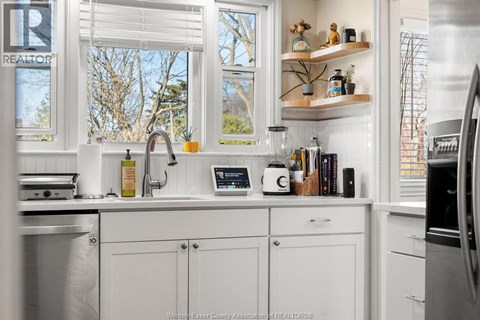 A kitchen with white cabinets and a window above the sink.