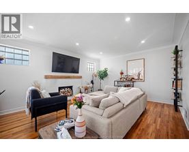 A living room with a couch, a chair, a coffee table, and a television.