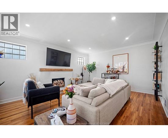 A living room with a couch, a chair, a coffee table, and a television.