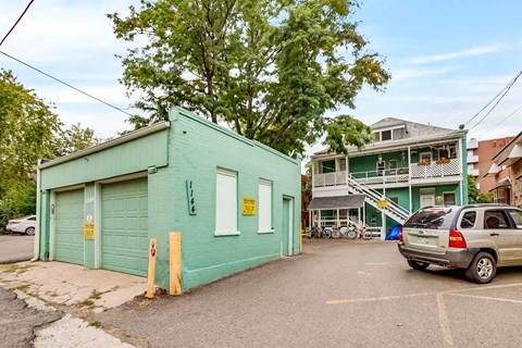 A green building with a garage door and a sign on the door.