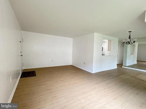 A large empty room with wooden floors and white walls.