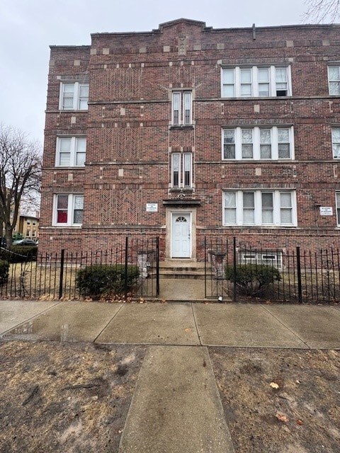 A brick building with a white door and windows.