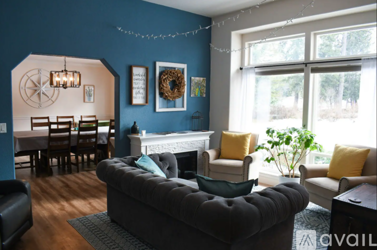 A living room with a grey sofa and a fireplace.