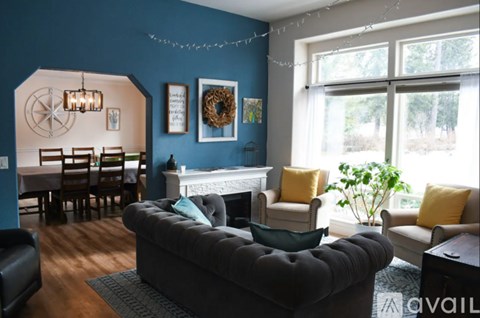 A living room with a grey sofa and a fireplace.