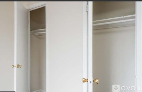 A white door with a gold handle is open.