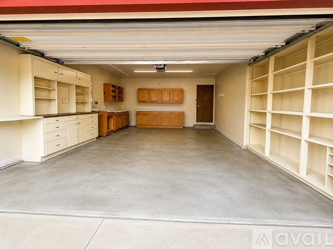 A spacious garage with shelving and cabinets.