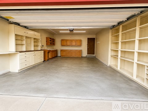A spacious garage with shelving and cabinets.