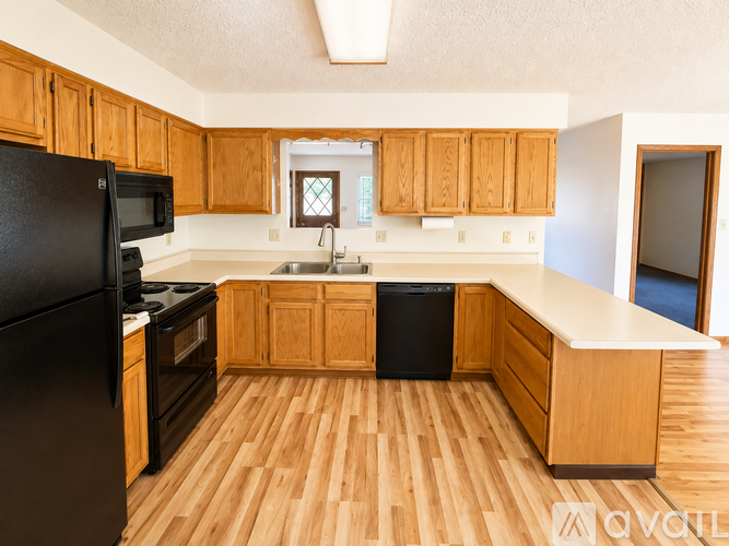 A kitchen with wooden cabinets and black appliances.