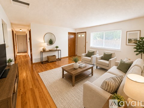 A living room with a wooden floor and furniture.
