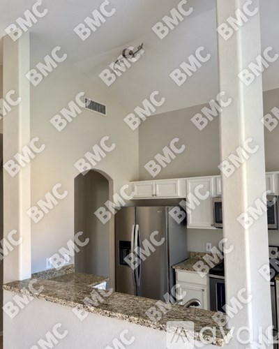 A kitchen with a stainless steel dishwasher and white cabinets.