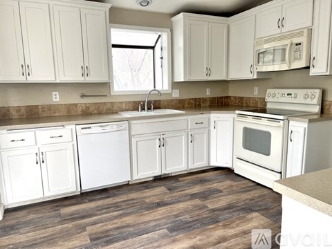 A kitchen with white appliances and cabinets.