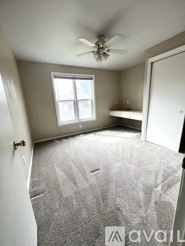 A room with a ceiling fan and a window.