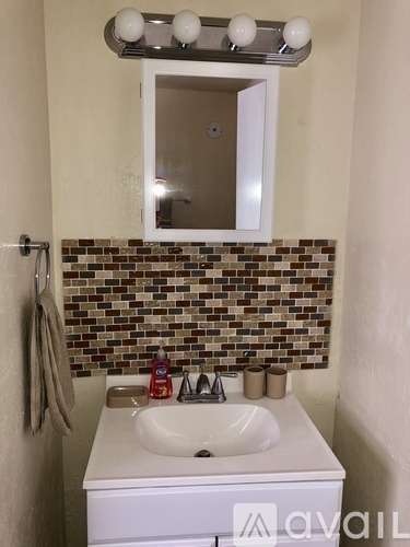 A bathroom with a white sink and a mirror above it.