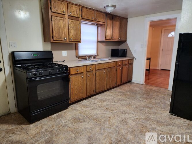 A kitchen with wooden cabinets and a black stove top oven.