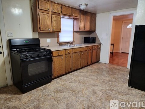 A kitchen with wooden cabinets and a black stove top oven.