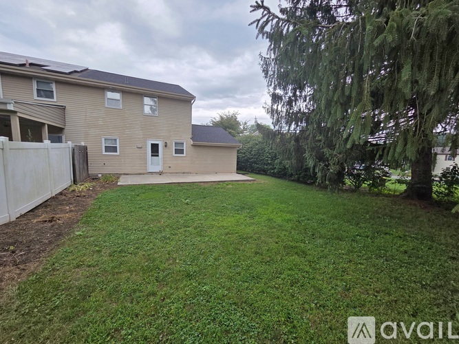 A backyard with a fence and a tree.