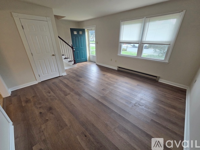 A room with wooden flooring and a white door.
