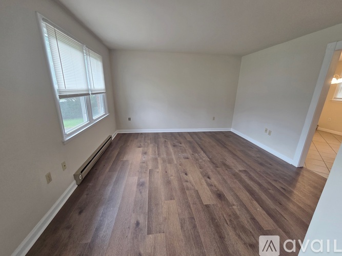 A room with wooden flooring and a window.