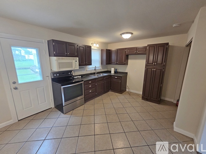 A kitchen with white appliances and brown cabinets.