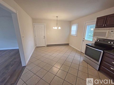 A kitchen with a microwave, oven, and stove top.