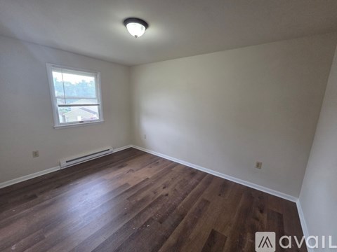 A room with wooden flooring and a window.