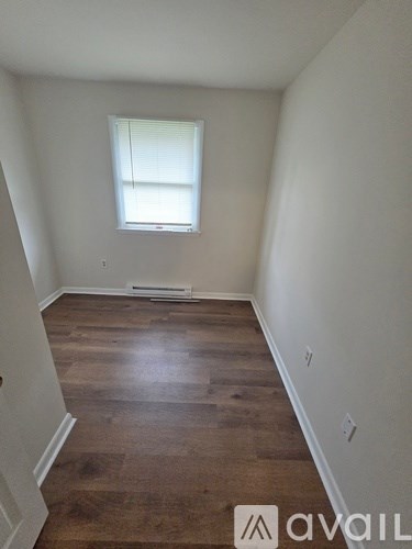 A room with wooden floors and a window.