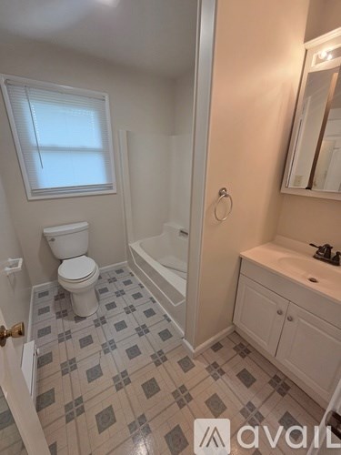 A bathroom with a toilet, sink, and bathtub.