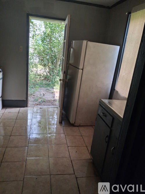 A kitchen with a refrigerator and a sink.