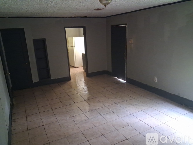 A room with tiled flooring and three doors.