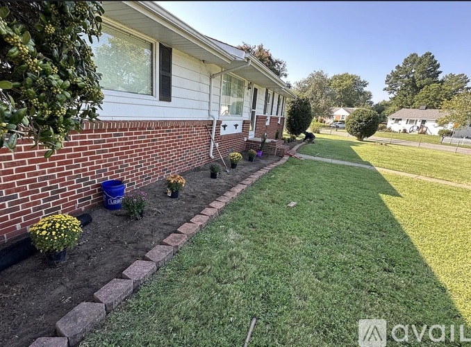 A house with a red brick wall and a well-maintained lawn.