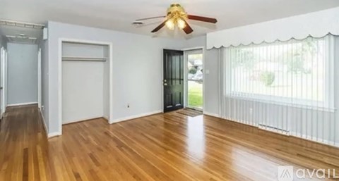 A room with wooden floors and a ceiling fan.