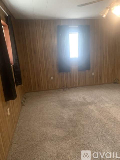 A room with wooden walls and a carpeted floor.