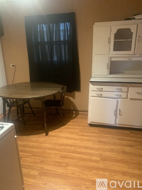 A kitchen with a table and chairs and a washing machine.
