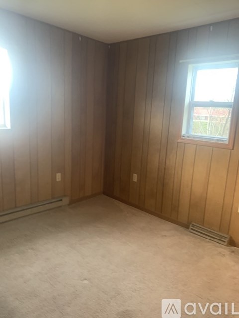 A room with wooden walls and a window.