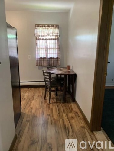 A kitchen with a wooden floor and a table with two chairs.