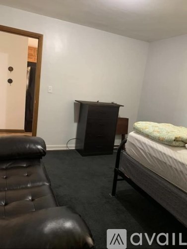 A bedroom with a bed, a couch, and a television.