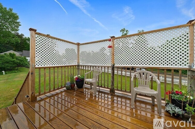 A wooden deck with a mesh screen and a chair.