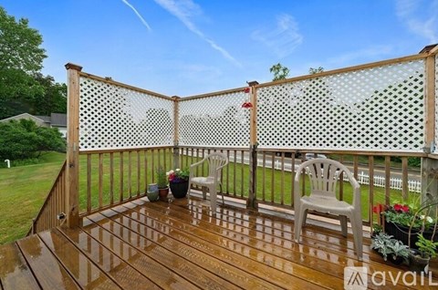 A wooden deck with a mesh screen and a chair.
