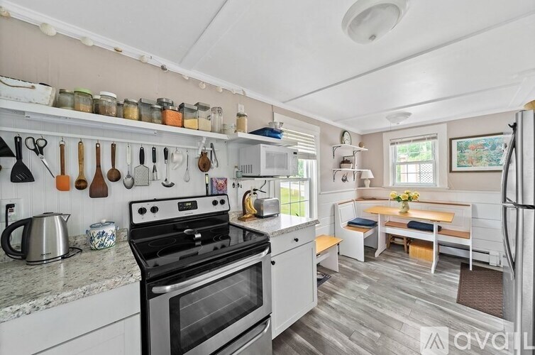 A kitchen with a stove, oven, and a table with chairs.
