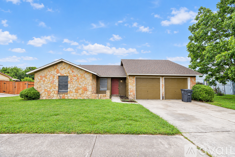 A house with a stone exterior and a brown roof with a garage door.