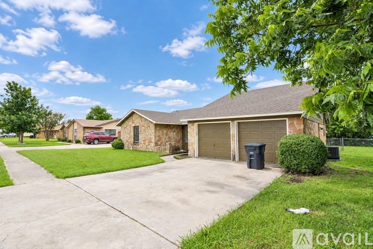 A house with a garage and a driveway in front of it.