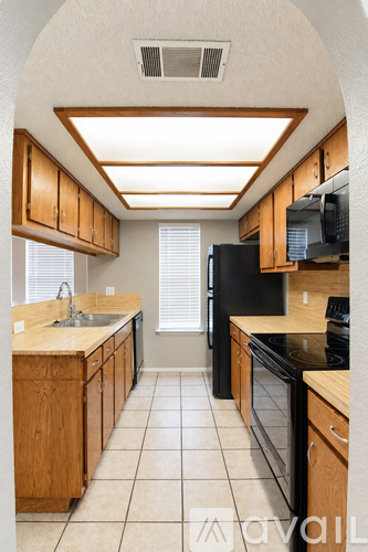 A kitchen with wooden cabinets and black appliances.